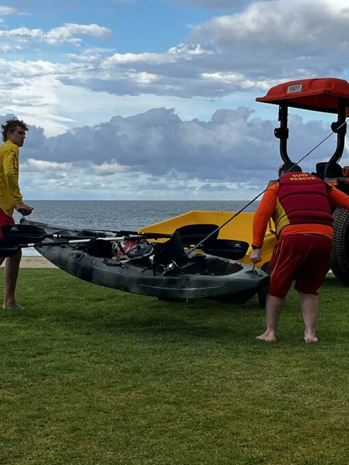 Surf life savers with one of the kayaks the men had been paddling when they got into trouble. Picture supplied