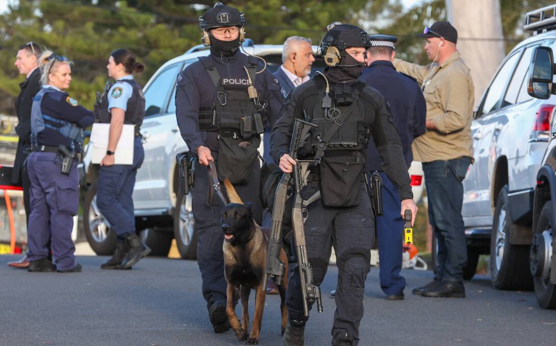 Police, including members of the Tactical Response Group, swarm across a Dapto street during a siege on August 15. Picture by Adam McLean 