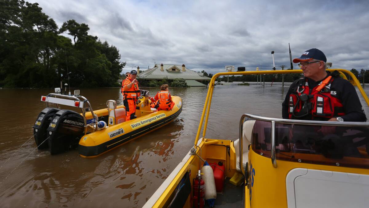 SES crews survey floodwaters in Windsor, near Sydney. Scientists warn extreme weather events will become more frequent as the planet warms. Picture: Getty Images