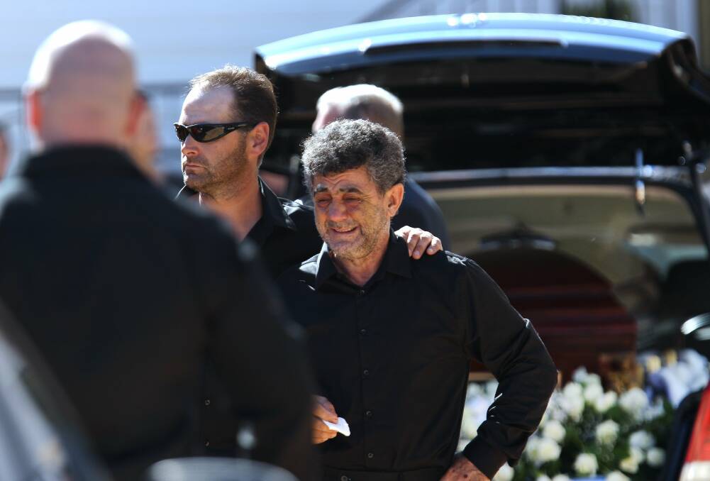 Slobodan Janceski is comforted by family at the funeral of his son, Darko Janceski, in  April 2012. 