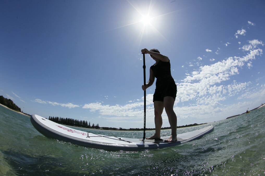 Candice Meaney of Newcastle takes a paddle around the Lake Illawarra foreshore in calmer morning conditions. Picture: DAVE TEASE