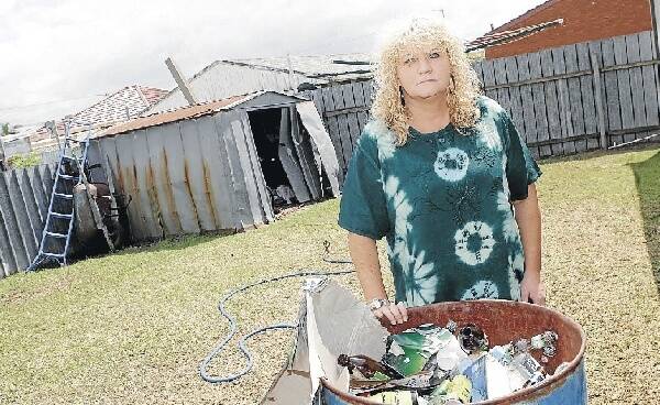 Sharon Flannery cleans up her backyard after a large number of gatecrashers ruined her son's 18th birthday celebrations. Picture: ANDY ZAKELI