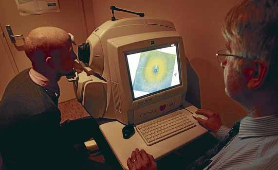 Optometrist Stephen Lorenzon with Matt Hoppo from OPSM and a retina scanning machine in Wollongong. Picture: ADAM McLEAN