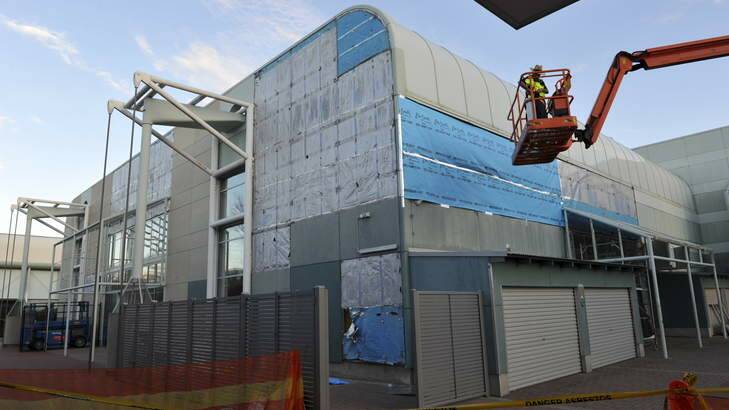 Asbestos cladding being removed from the exterior of the swimming pool building at the Australian Institute of Sport. Photo: Graham Tidy