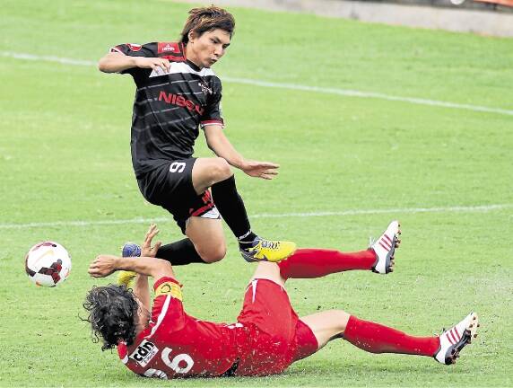 Close call: Blacktown City’s Ryuji Miyazawa leaps to avoid a nasty collision with South Coast Wolves’ Jacob Timpano at WIN Stadium on Sunday. Blacktown totally dominated the match to win 5-0. Picture: GREG TOTMAN