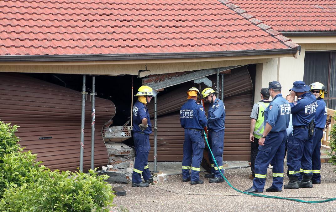 Fire crews attempt to prop up the garage  after the van crashed into the front of it. Pictures: KIRK GILMOUR 