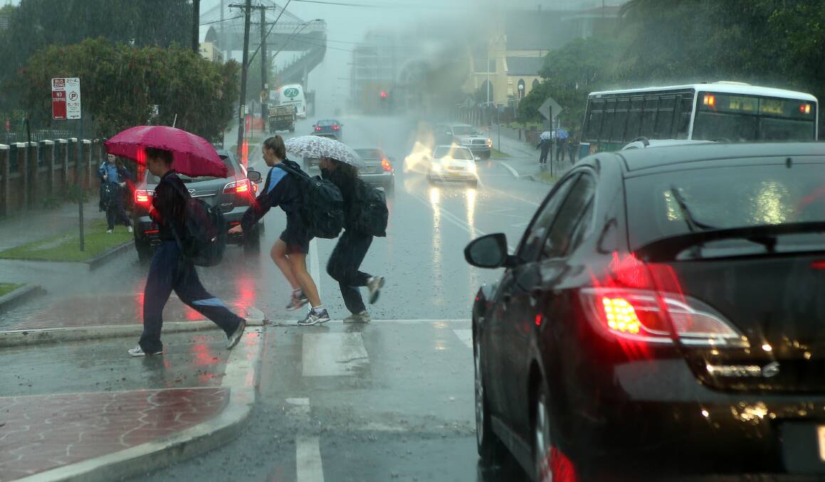 St Mary’s College students sprint from the bus to school in driving rain. Picture: KIRK GILMOUR