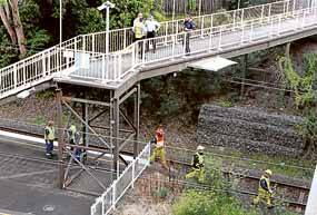 Emergency service and CityRail crews inspect the scene of last night's accident at Coledale Railway Station.