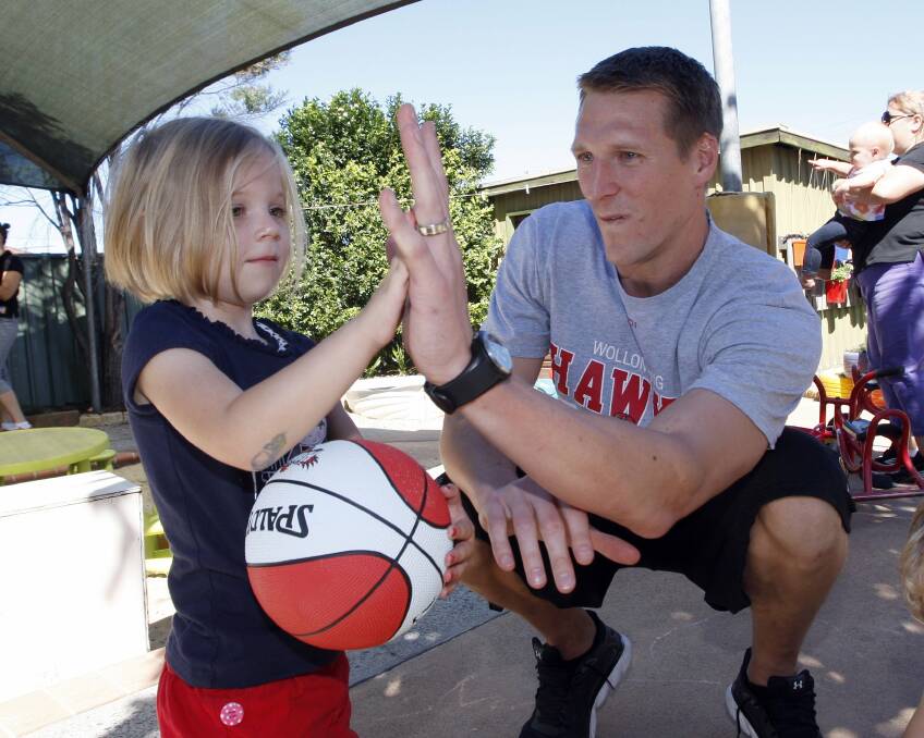 Hawks forward Dave Gruber high-fives Ruby, 5, at Kenny Street Community Preschool in Wollongong. Picture: ANDY ZAKELI