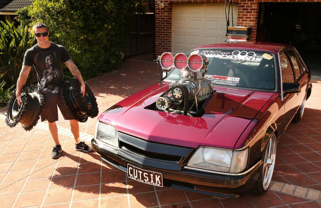 Craig Whiddett, holding a couple of shredded tyres, and his specially prepared VK Commodore. Picture: KIRK GILMOUR