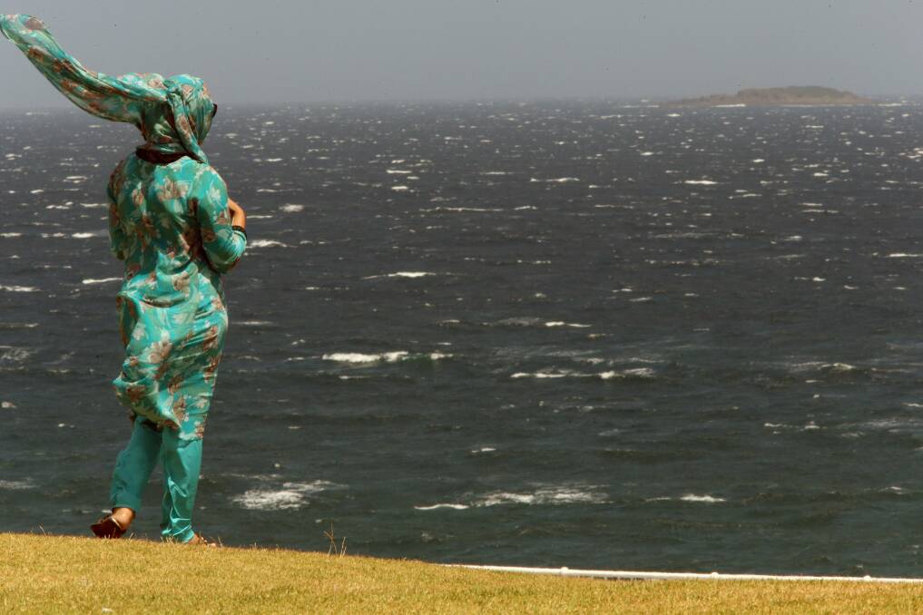 A woman’s headwear flies behind her as she checks out the view from Flagstaff Hill. Picture: ADAM McLEAN