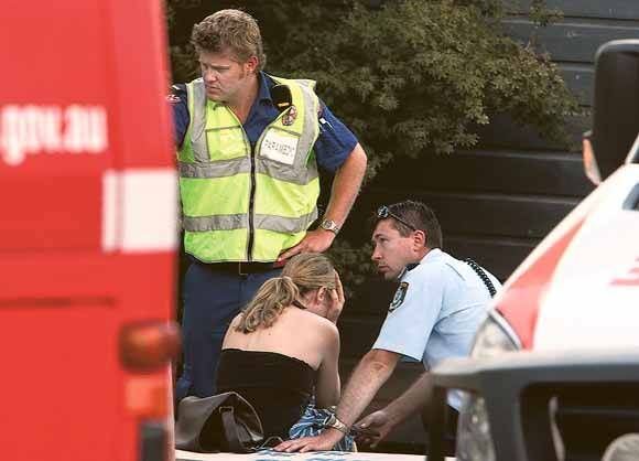 A woman is comforted at the scene after a girl was killed by a commuter train. Pictures:  KEN ROBERTSON and KIRK GILMOUR