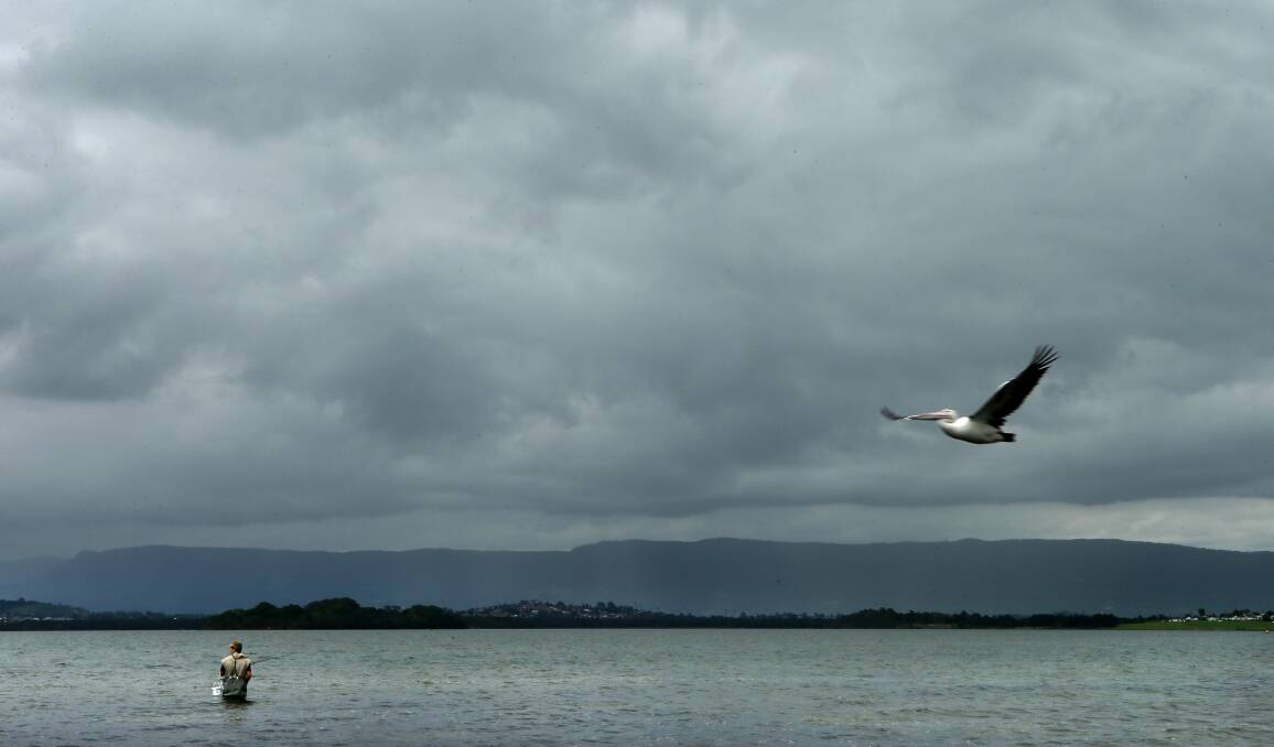 Stormy weather: A fisherman tries his luck on Lake Illawarra after February's first days of overcast and rainy conditions.