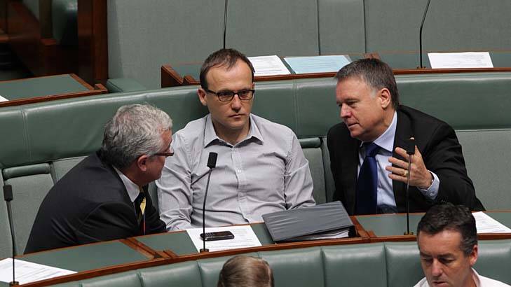 Independent MP Andrew Wilkie and Greens MP Adam Bandt speak with Chief Government Whip Joel Fitzgibbon during a division in the House of Representatives on Thursday morning.