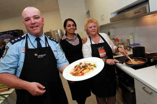  Insp Steve Johnson shows off his dish, as judge Dalvinder Dhami and overall winner Merika Fulton look on at the Lake Illawarra command's cook-off. Picture: ORLANDO CHIODO