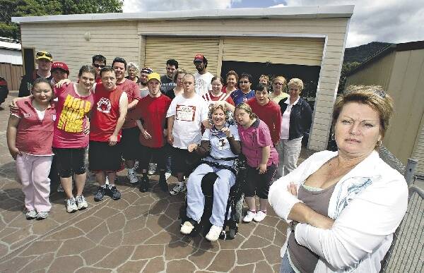 Cathy Potter (right) with some of the disabled adults and their carers at the disused garage in Tarrawanna they are using as temporary premises. They left Rui's Place in Balgownie after a management upheaval. Picture: KIRK GILMOUR