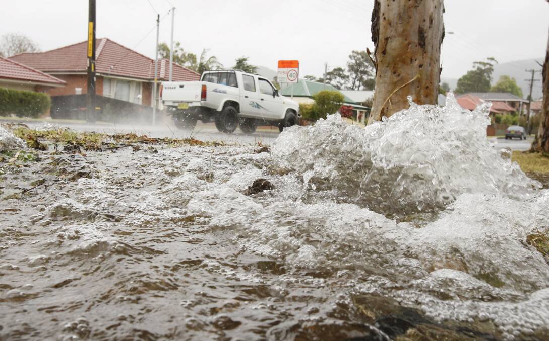 A broken main causes flooding on Mount Keira Road yesterday.  Picture: DAVE TEASE