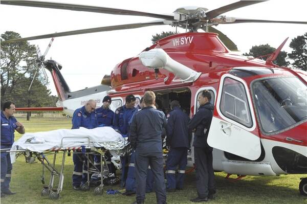 The seriously injured man is loaded into a helicopter after he was impaled on a stake after coming off a motorcycle. Picture: FRANCES RAND, South Coast Register