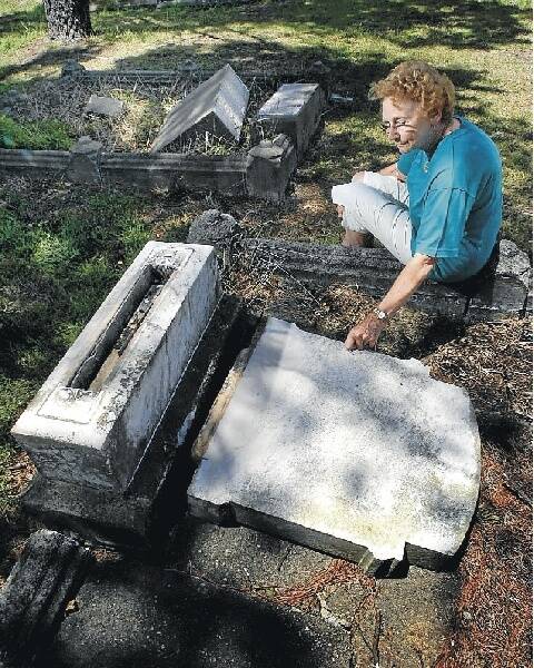 Elaine Carr with her desecrated great-grandparents' grave at Wollongong Cemetery. Picture: KIRK GILMOUR