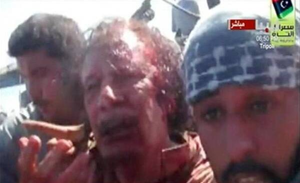 Former Libyan leader Muammar Gaddafi, covered in blood, is pulled from a truck by NTC fighters in Sirte in this still image taken from video footage. Photo: REUTERS