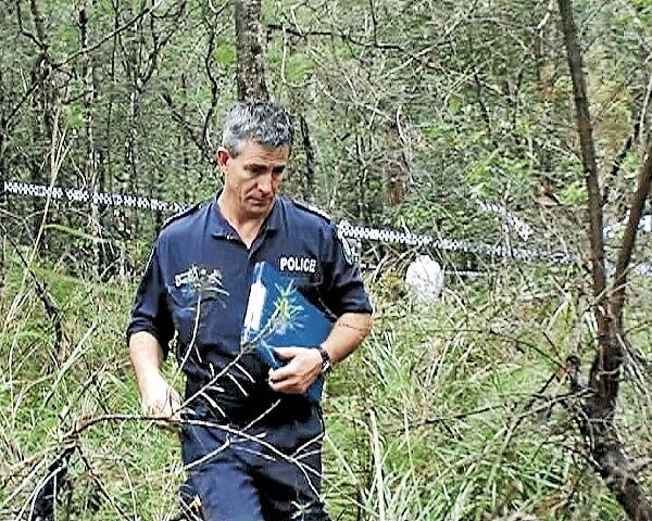 Police officers search for evidence and take pictures in the Currowan State Forest at Nelligen, near Batemans Bay.