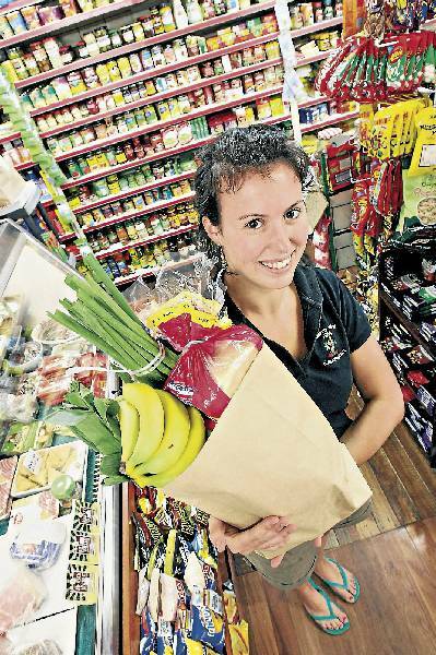 Kangaroo Valley Supermarket shop assistant Claire Bowley uses brown paper bags in accordance with the town's plastic bag ban. Picture: KEN ROBERTSON