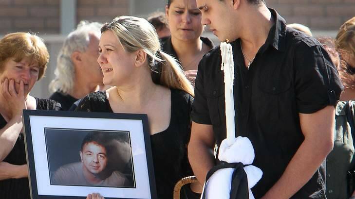 Family hold a portrait at the funeral of Darko Janceski.