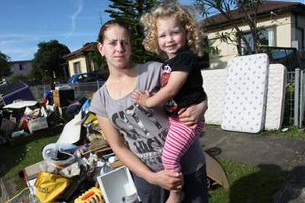 Farah Baydoun and daughter Lamar Jaasar, 2,  alongside  damage caused by  flooding in Kembla St. Picture: MELANIE RUSSELL