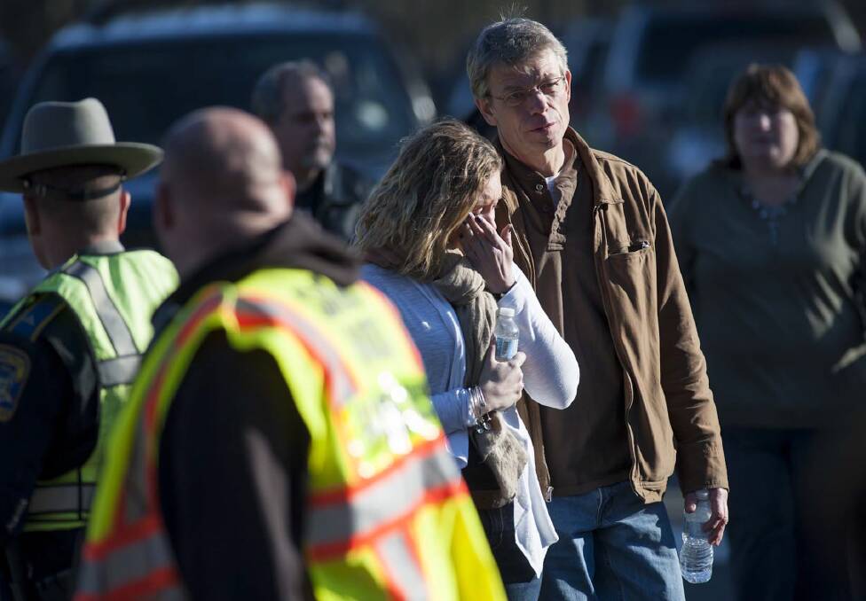 Grieving residents near the scene of the shooting at Sandy Hook Elementary School in Newtown. Picture: NEW YORK TIMES