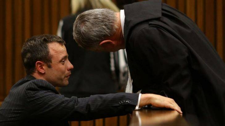 Distressed ... Oscar Pistorius cries as he talks to his attorney Barry Roux, right, after listening to evidence during his trial in Pretoria. Photo: AP Photo