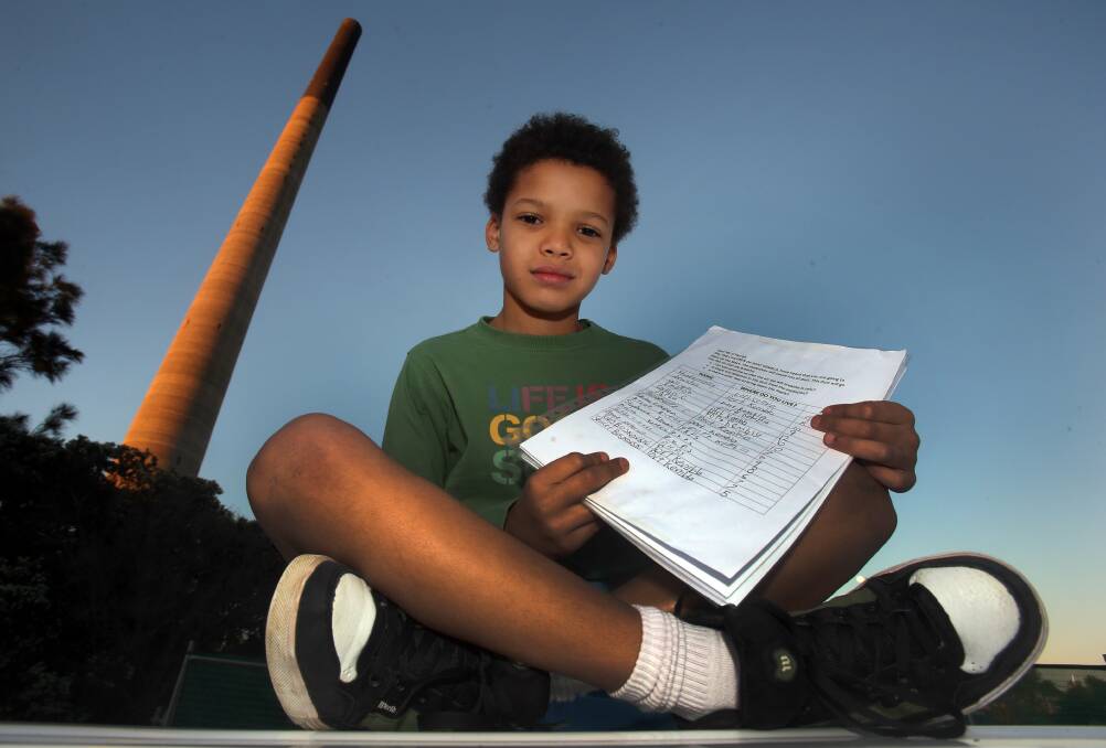 Tabani Moyo, 9, holds his Port Kembla stack petition. Picture: ROBERT PEET