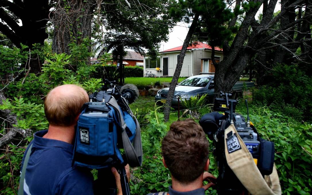 News crews at the back of the Bulli house where a woman's body was found on Friday. Picture KIRK GILMOUR