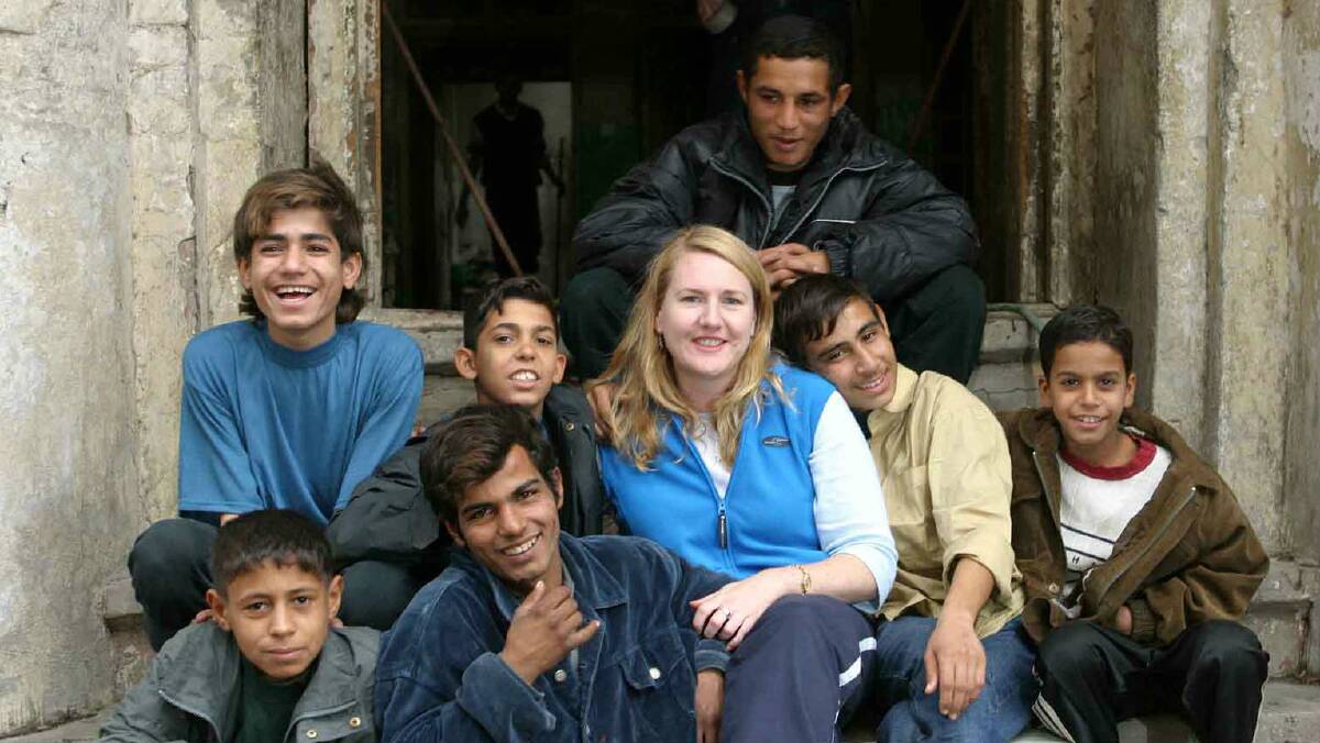 Donna pictured with street kids she worked with in Baghdad in 2003.