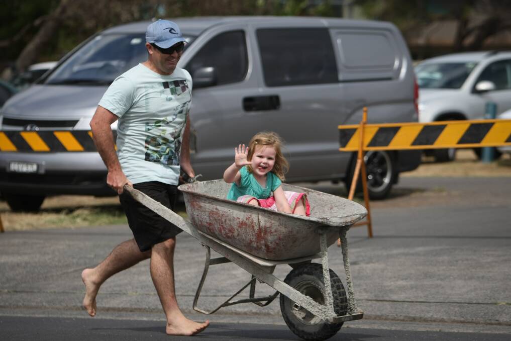 Kiama's Bob Willetts puses his daughter Elysse, 3, in the brickies race at Kiama. Pictures: Dylan Robinson
