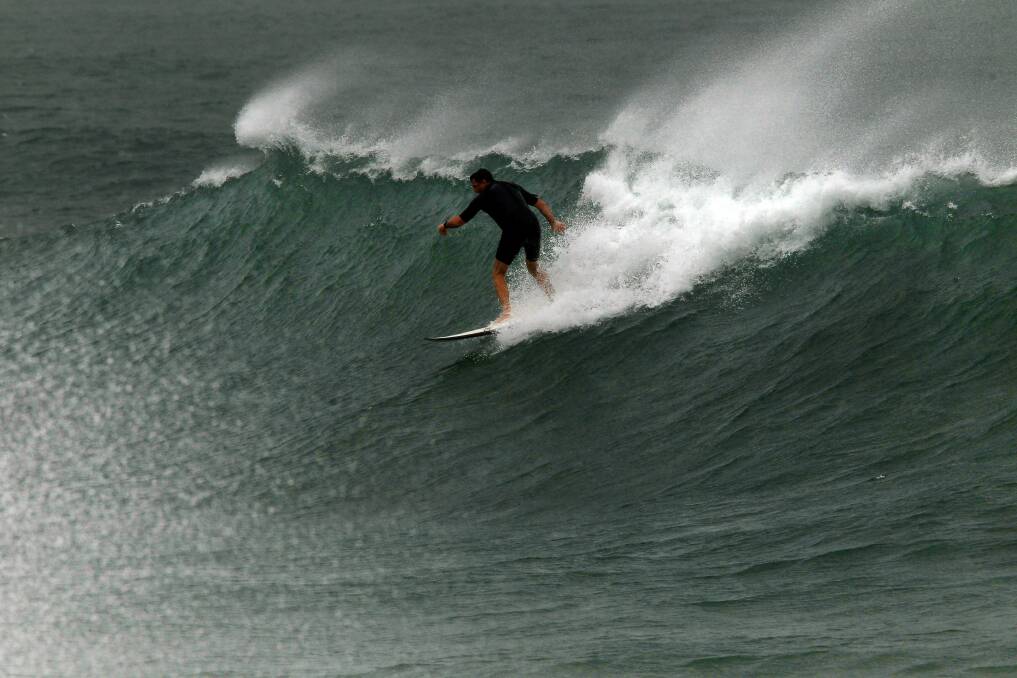 Surfers and body boarders take on big waves at The Farm. Pictures: SYLVIA LIBER