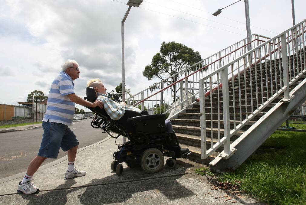 Brian Langlands and Richard Kramer in a wheelchair outside Unanderra Train Station.