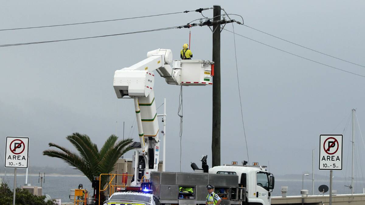 Emergency crews repair fallen power lines in Wollongong yesterday morning. Picture: SYLVIA LIBER