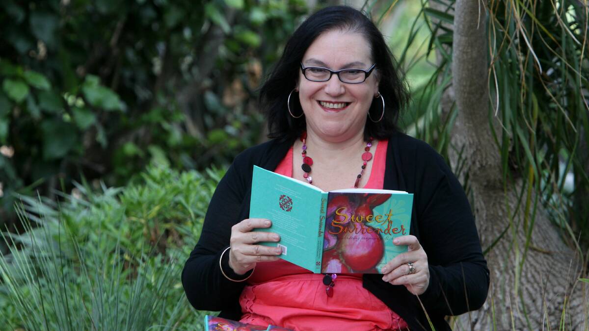 Midwife Karen Buckley with a copy of Sweet Surrender. Picture: GREG TOTMAN