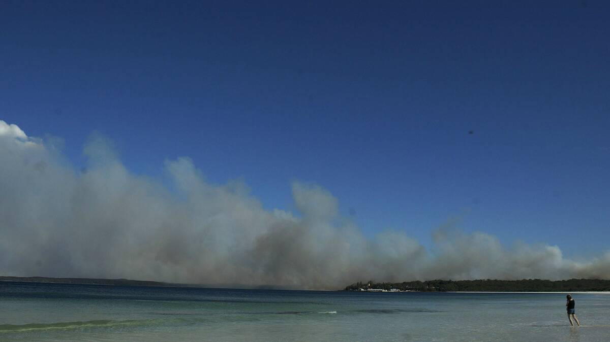 Swimmers on Hyams Beach in Jervis Bay watch the smoke from fires in 2003. Picture: KATE GERAGHTY