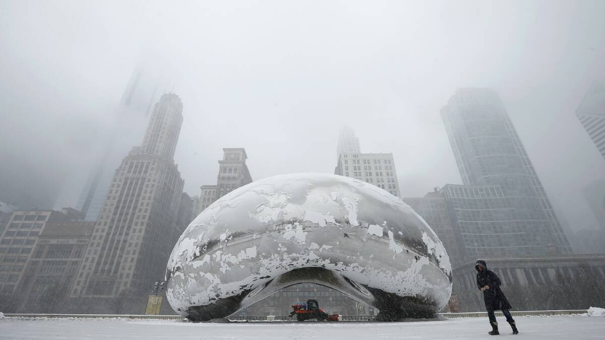 A woman walks past the Cloud Gate sculpture, known as The Bean, in Chicago. Picture: REUTERS