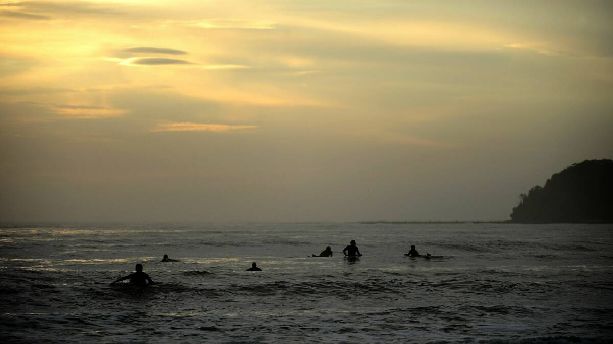 Surfers wait for waves at Broulee Beach. Picture: STUART WALMSLEY