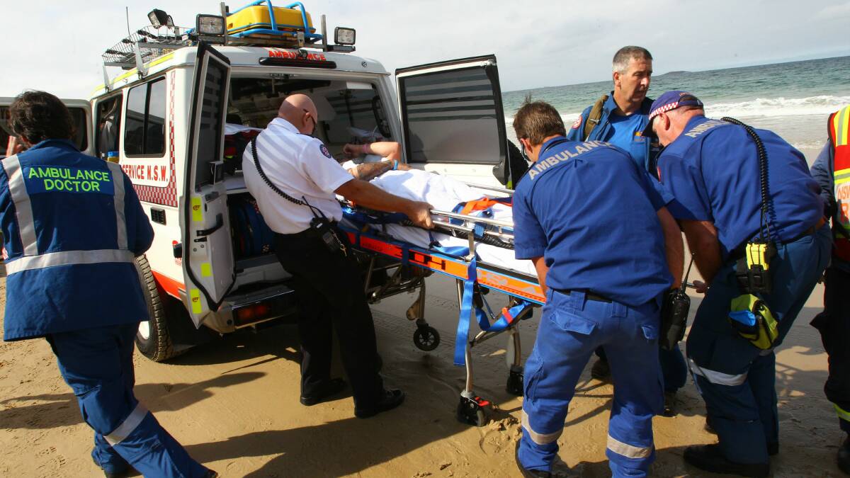  Emergency workers carry the injured paraglider. Picture: KEN ROBERTSON