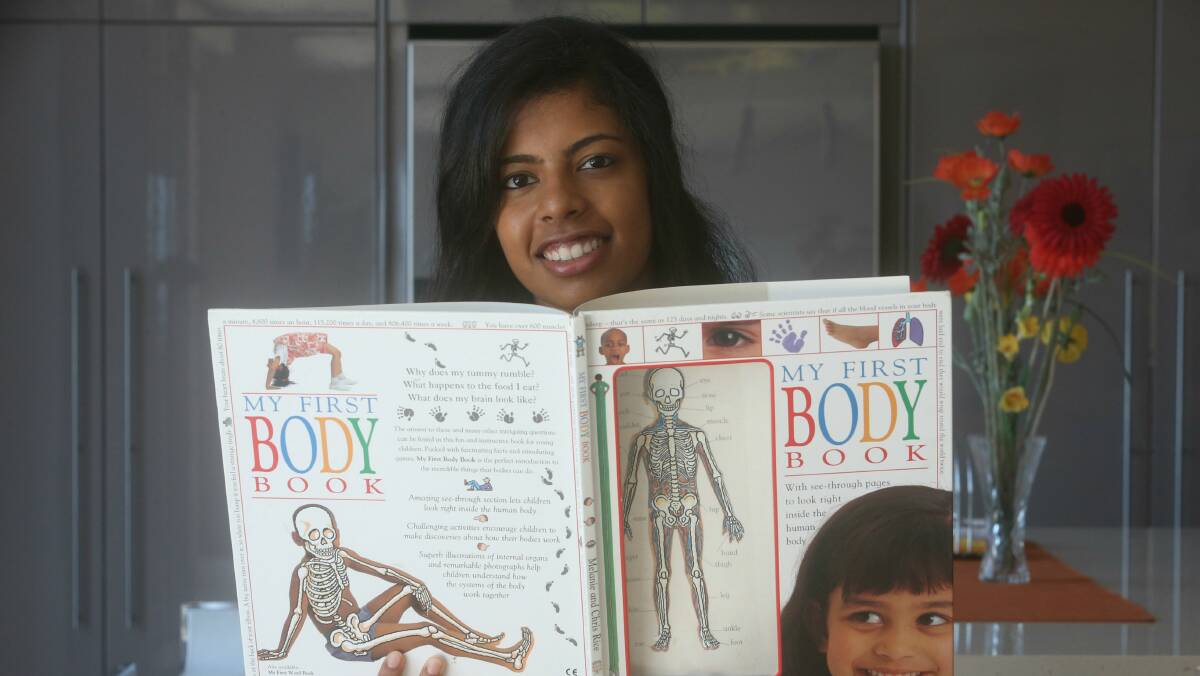 Lisa Fernandez holding the first book she was given about the human body. Picture: ROBERT PEET