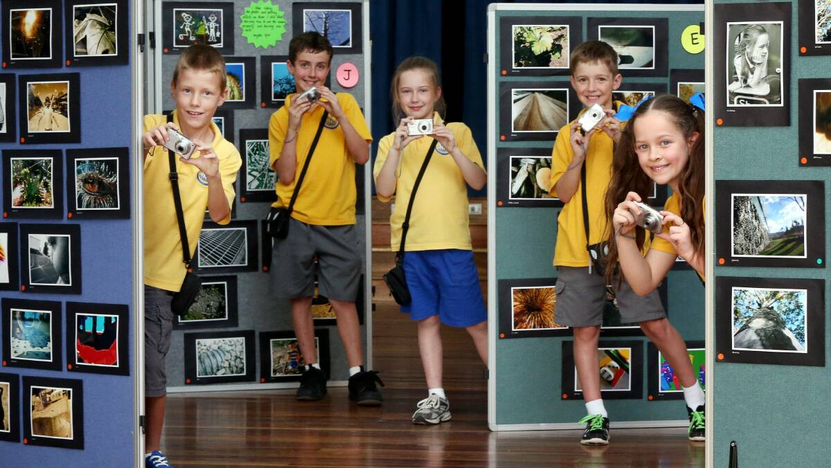 Jack, James, Tara, Conor and Mykenzie with photos from the Dapto Public School exhibit. Pictures: ADAM McLEAN 