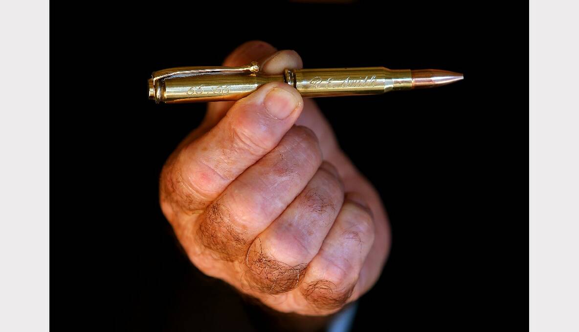 Holding a momento of a AK47 bullet made into a pen.