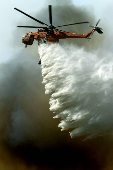 An aircrane helicopter bombs the bushfires near Wilton.