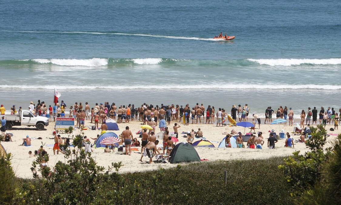 Beachgoers watch from the safety of the sand as lifesavers coerce a shark back out to sea. Pictures: ANDY ZAKELI