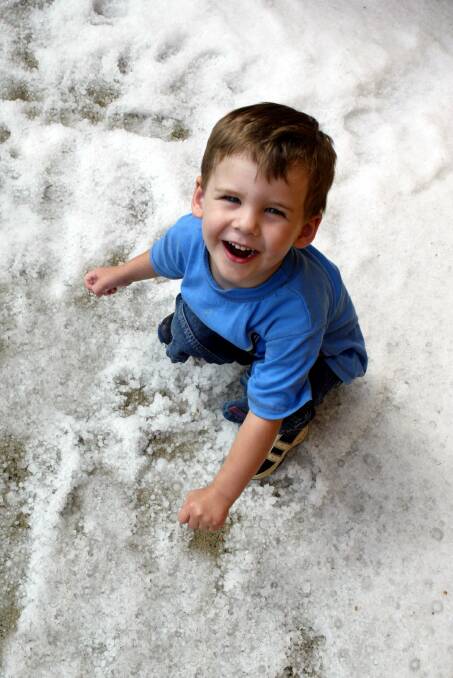 She'll be white: Samuel, 3, plays in a white carpet of hail.