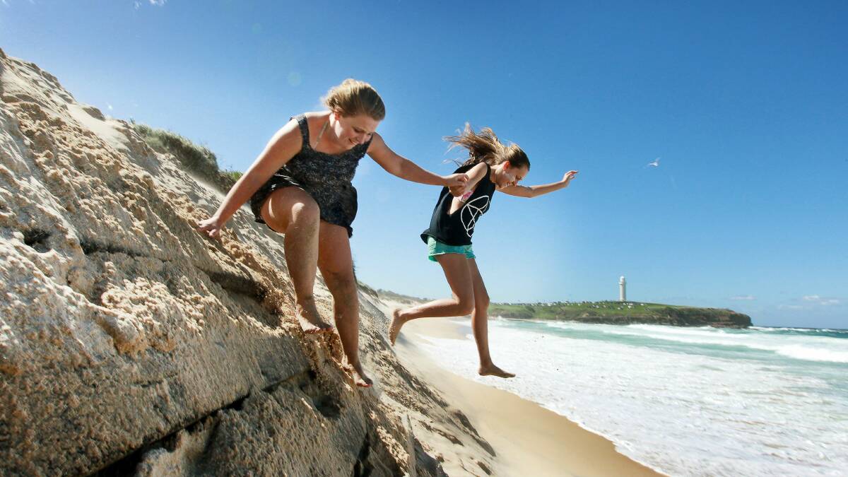 Eroded sand: Ashleigh (left) and Michaela play at City Beach, Wollongong, in November last year.