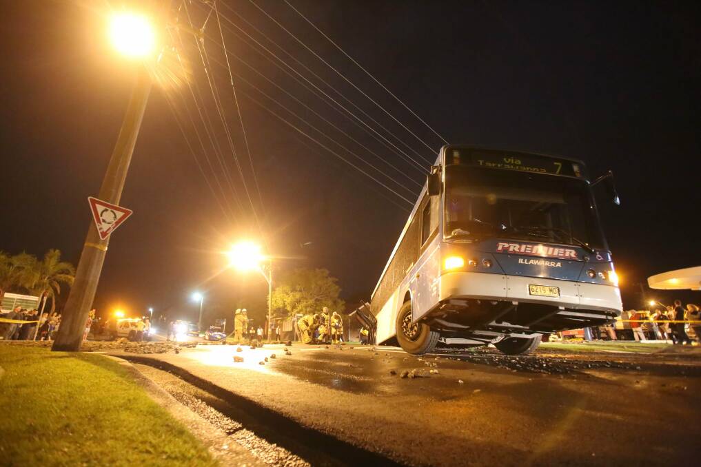 A burst water main tries to swallow the No 7 bus to Tarrawanna at the corner of Balgownie and Foothills Rd, opposite the Fuel Power Plus petrol station. Pictures: DAVID FINLAY